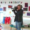 Pictured is camerman Mike Turnbull taking a moment to listen to children at The Old Station Nursery's Innsworth setting while filming a documentary on childcare costs