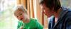 Teacher and seven year old boy counting blocks cropped