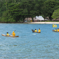 Scientology Volunteer Ministers Goodwill Tour leaders and team of locally trained Volunteer Ministers paddle canoes across the bay to the village of Lambi in Guadalcanal.
