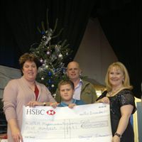 Harry Jewitt receives a cheque for £500 from Selby Music Centre for Great Ormond Street