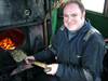 Adrian Dennis, steam locomotive fitter for the North Yorkshire Moors Railway with a shovel full of pound coins