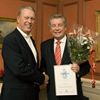 Ulf G. Ryder mottager blomma och diplom av Gert Malmberg