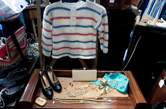 A display case with a sweater and shoes
AI-generated content may be incorrect.