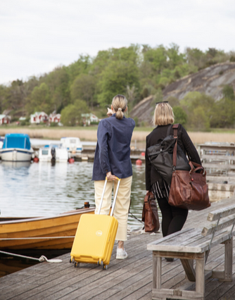 Two women walking on a dock with luggage
AI-generated content may be incorrect.