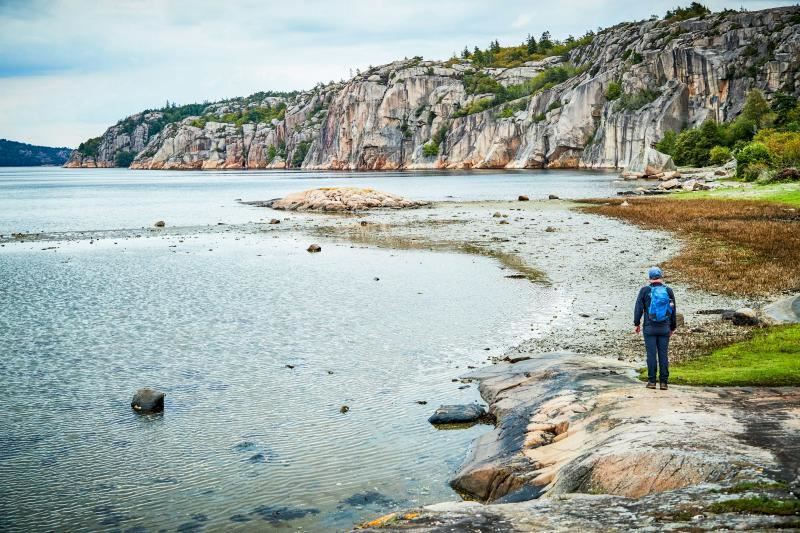A person standing on a rocky shore
AI-generated content may be incorrect.