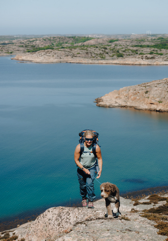 A person with a dog on a rock by water

AI-generated content may be incorrect.