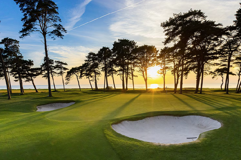 A golf course with sand bunkers and trees
AI-generated content may be incorrect.