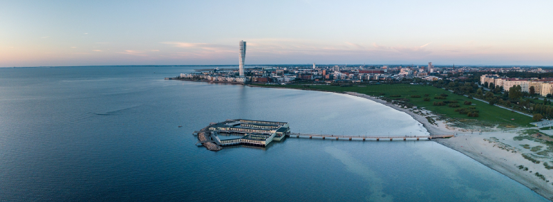 A body of water with a city in the background

AI-generated content may be incorrect.