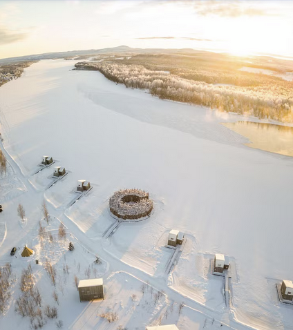 A snow covered area with buildings and a body of water
AI-generated content may be incorrect.