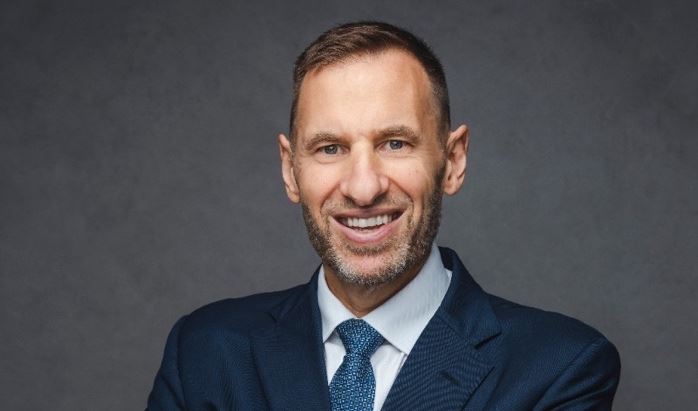 A person in a suit with his arms crossed

AI-generated content may be incorrect.